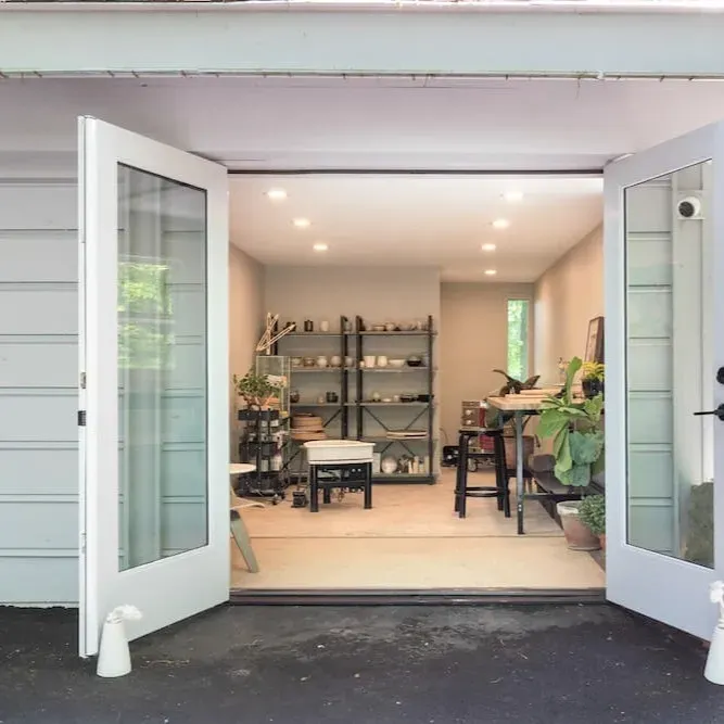 Stylish Myrtle Beach garage conversion featuring modern interior, hardwood floors, coastal views, lush landscaping, and contemporary decor