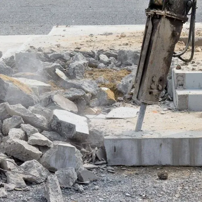 Clean Myrtle Beach concrete removal site with excavated soil, tools, modern buildings, palm trees, and ocean view