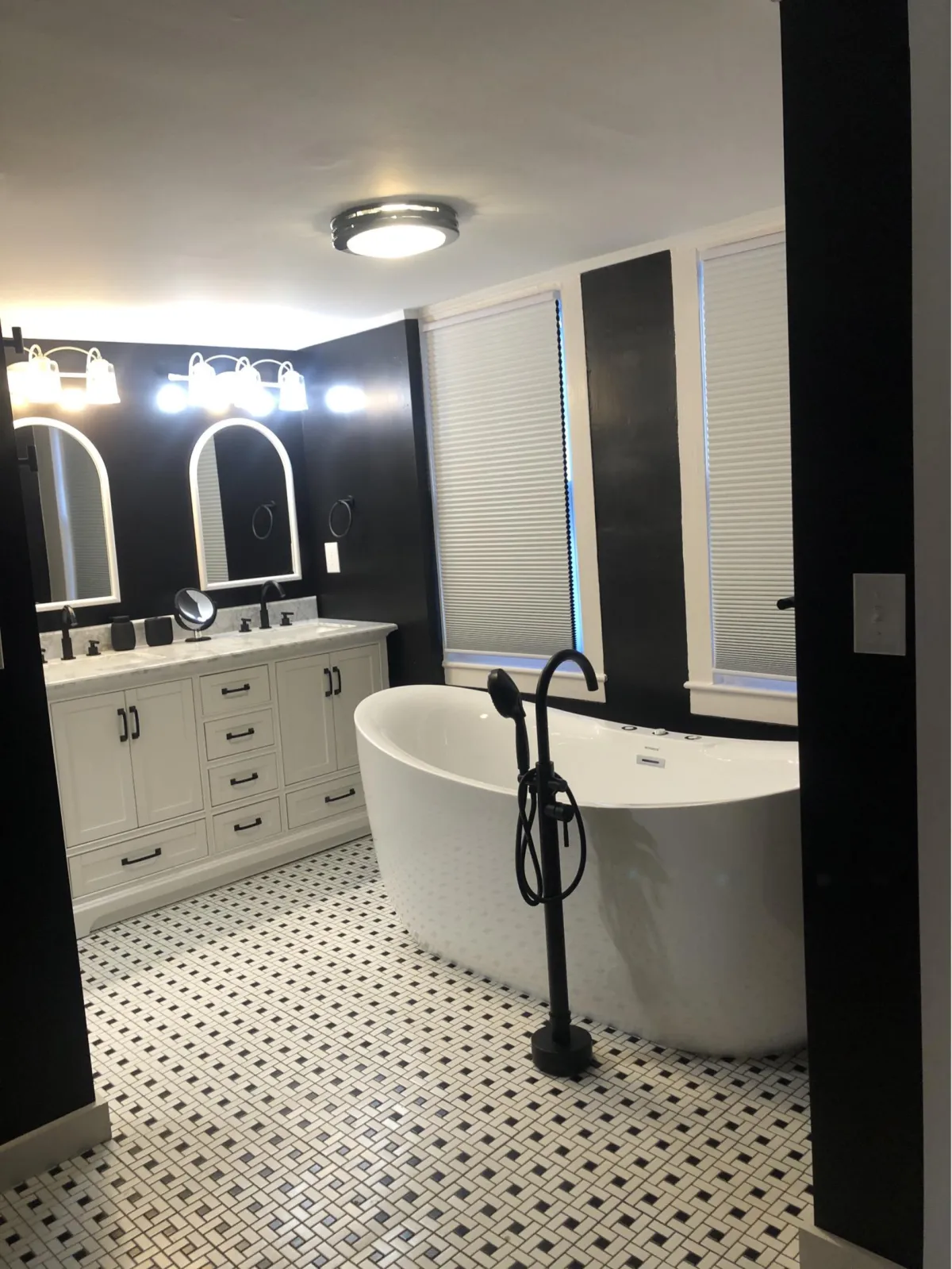 Finished bathroom with freestanding tub, double vanity, and tile flooring