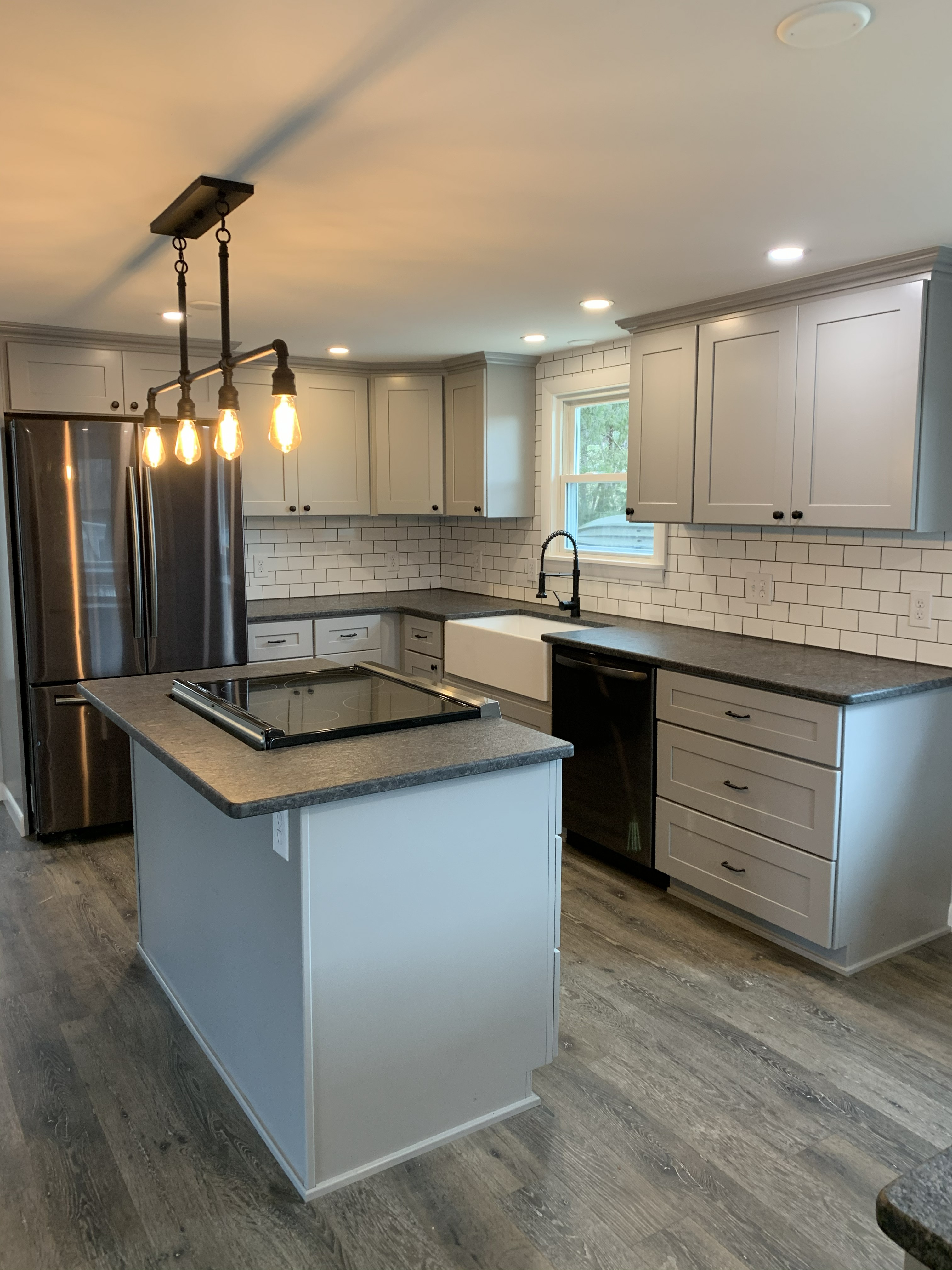 Finished kitchen with island, farmhouse sink, and white cabinets