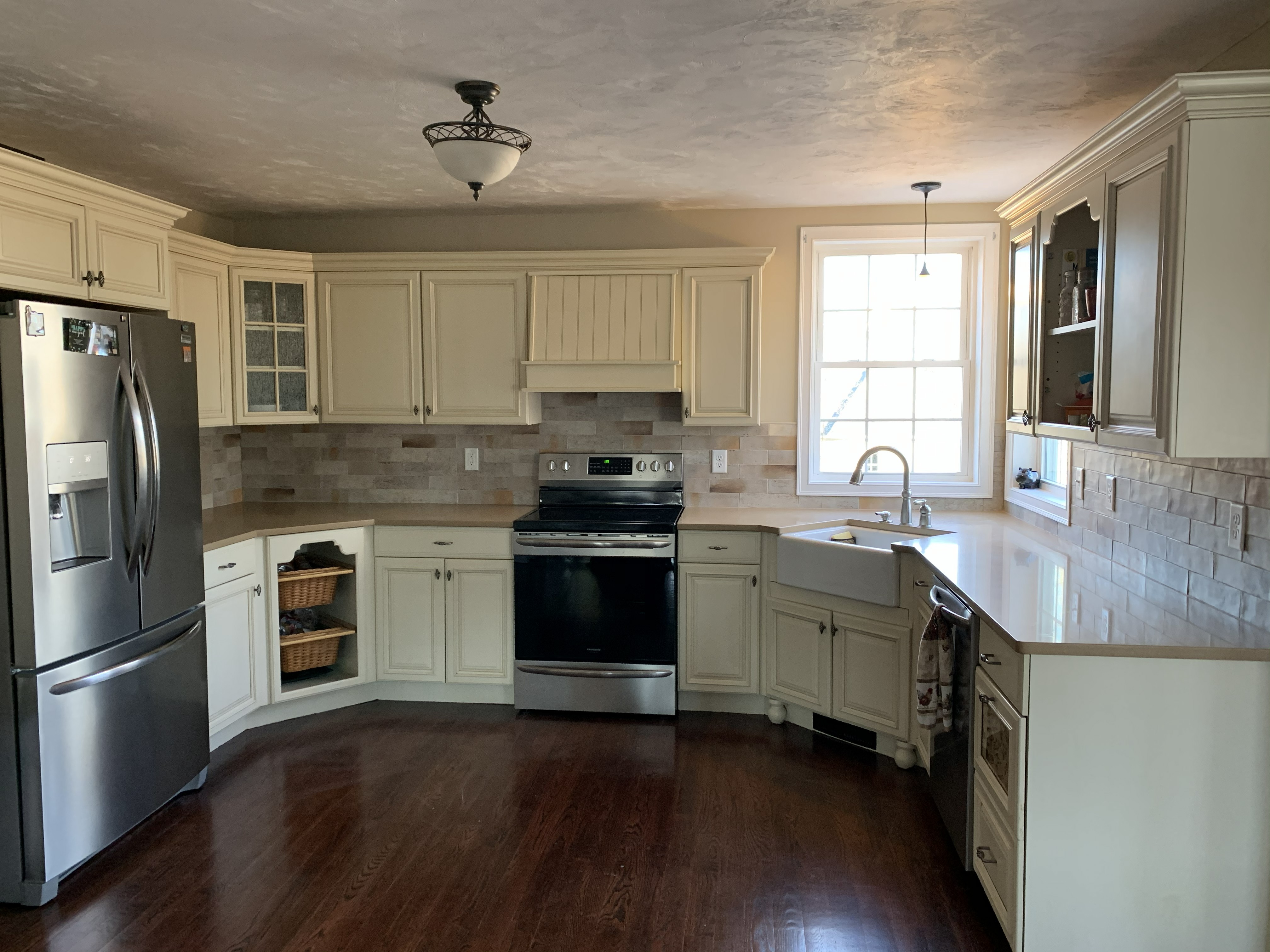 Kitchen remodel with white cabinets, farmhouse sink, and tile backsplash