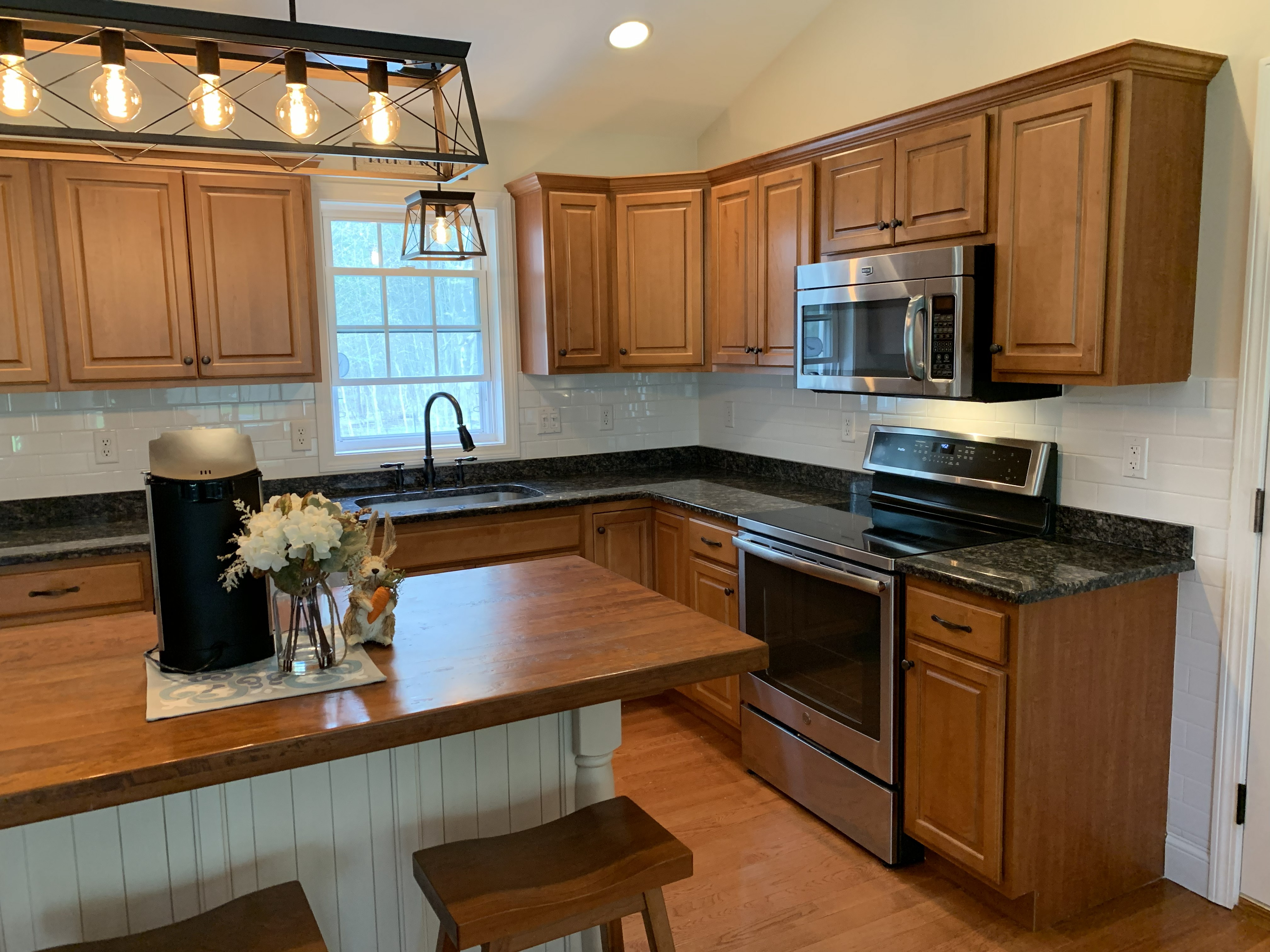Finished kitchen with wood cabinets, island, and stainless steel appliances