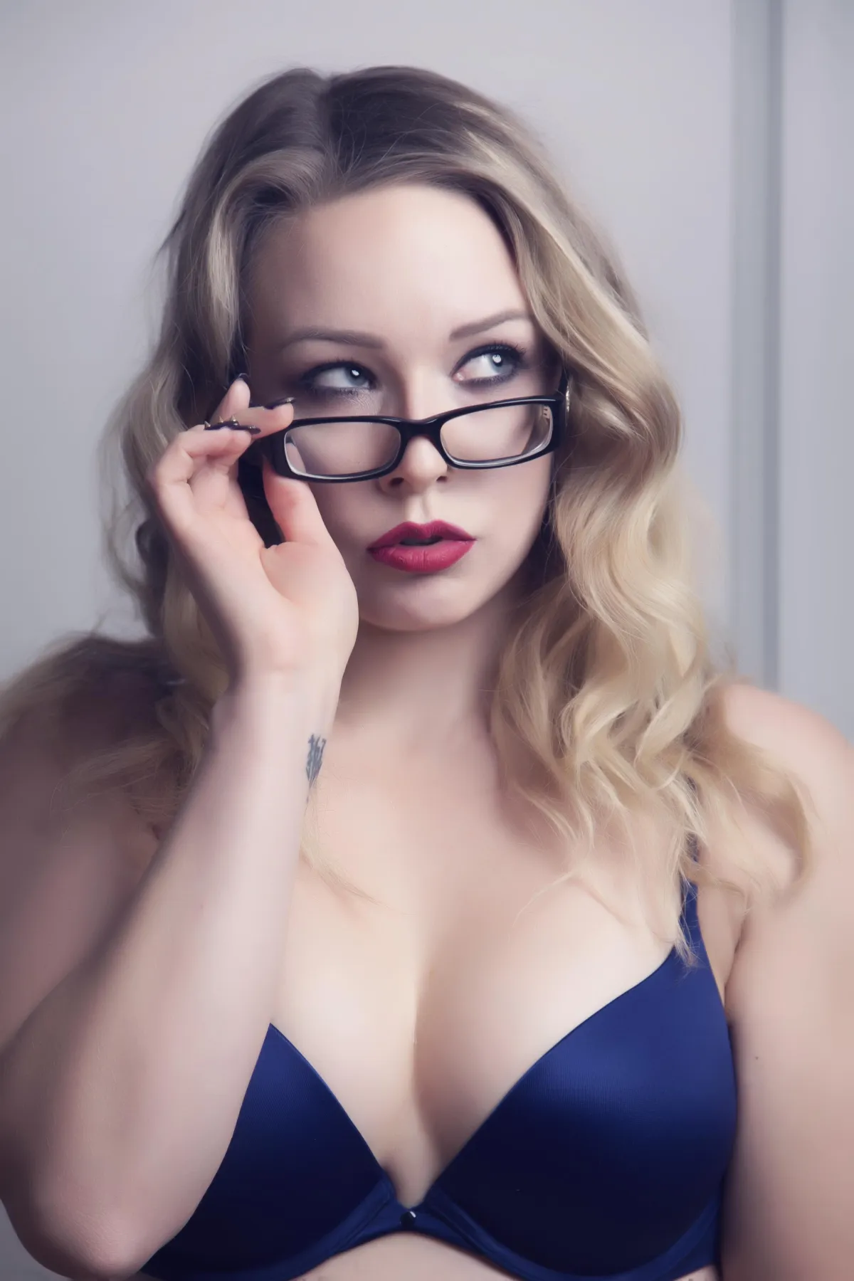 stunning boudoir photograph taken by Jodi blond woman with glasses and purple bra