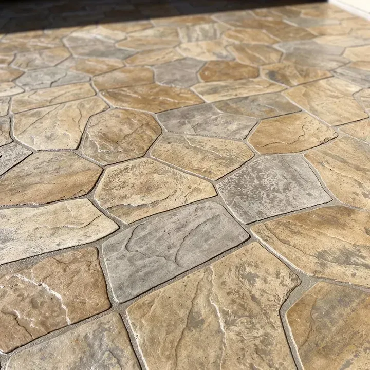 Close-up of freshly finished stamped concrete surface with realistic flagstone pattern and earthy color tones.