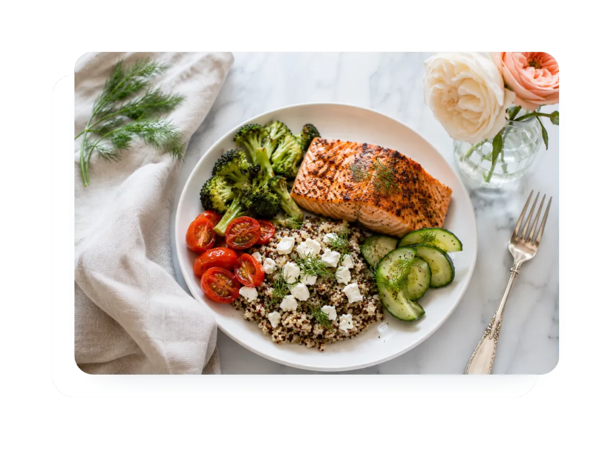 A bright, healthy plate of salmon, roasted broccoli, quinoa, tomatoes, and cucumber