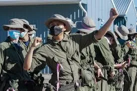 a man standing with his arms crossed in front of a white wall