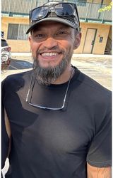 man in blue denim top standing under tree leaf