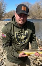 man in blue denim top standing under tree leaf