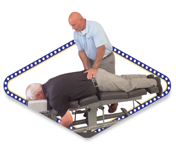 Dr. Dale Kimberlin performing drop table chiropractic adjustment technique for male patient's lower back pain treatment at Kimberlin Chiropractic Health Systems Ankeny Iowa.