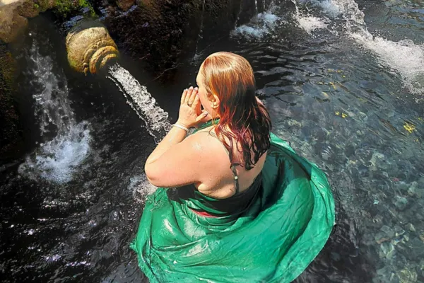 Julie in a quiet moment of pause and reflection, grounded in her body and connected to herself. The image should evoke taking a breath, listening inward, and creating space before responding — calm, embodied, and self-connected rather than confrontational.