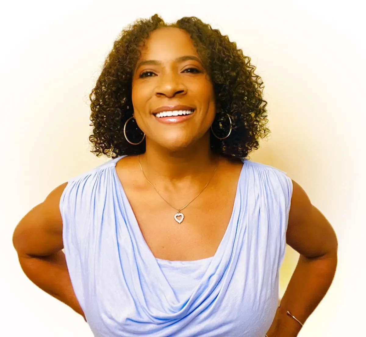 Woman resting hand on heart in soft pink light