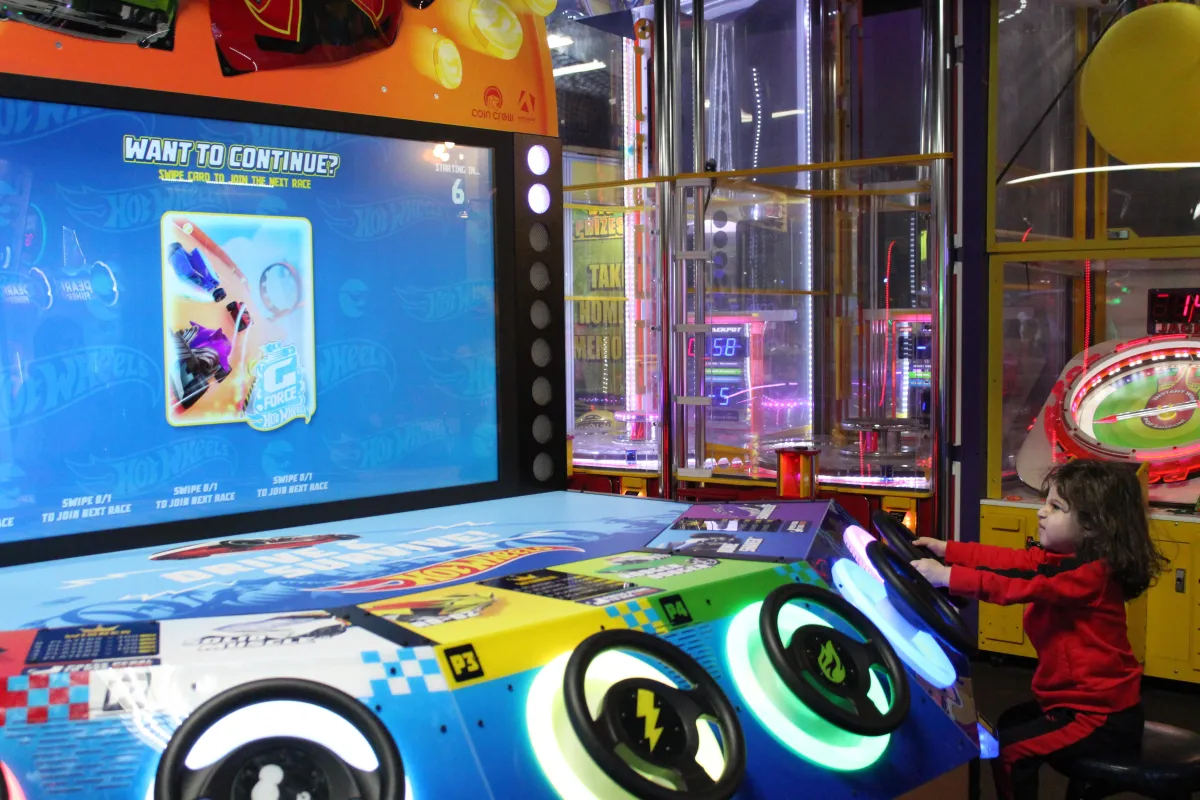 A kid playing a racing game in Action City