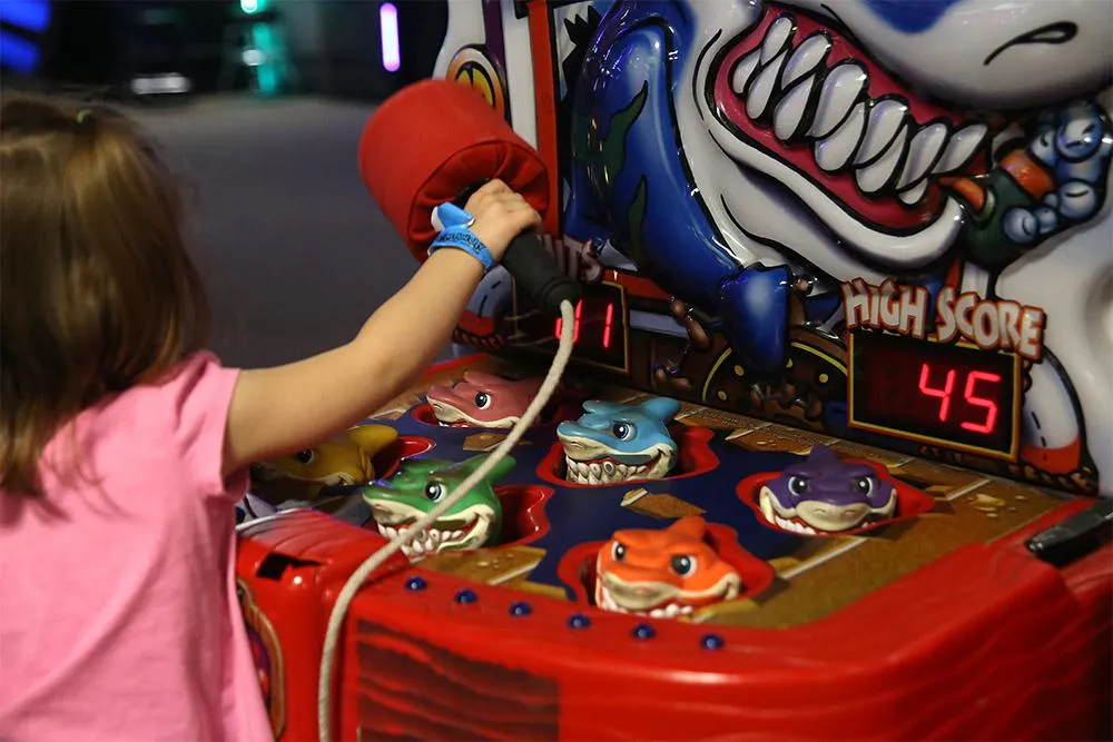 A kid playing the Hammerhead whack-a-mole game in Action City