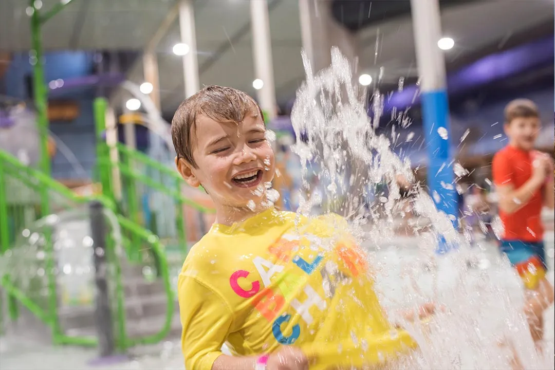 A boy playing in the indoor aquatic playground at Chaos Water Park
