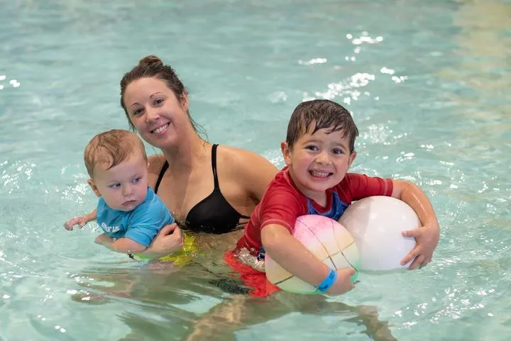 A mom and her kids playing in the activity pool at Chaos Water Park