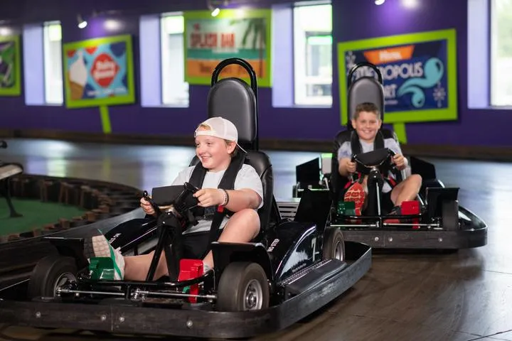 Kids racing on the indoor go-karts in Action City