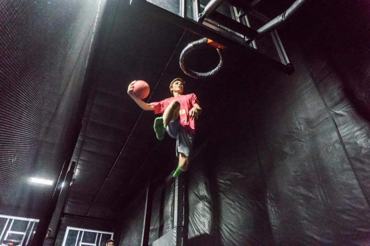 A guest at the slam dunk basketball in the trampoline park at Action City