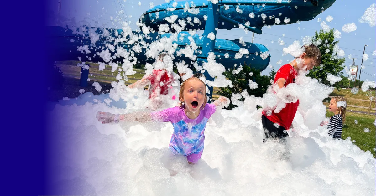 Kids playing under the dump bucket at the indoor aquatic playground in Chaos Water Park