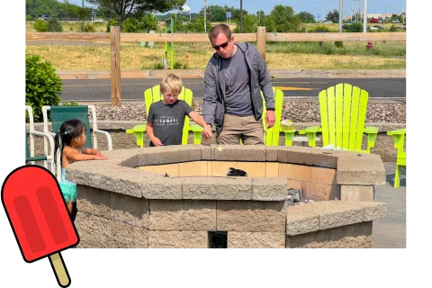 A dad and son making roasting marshmallows in Chaos Water Park's backyard