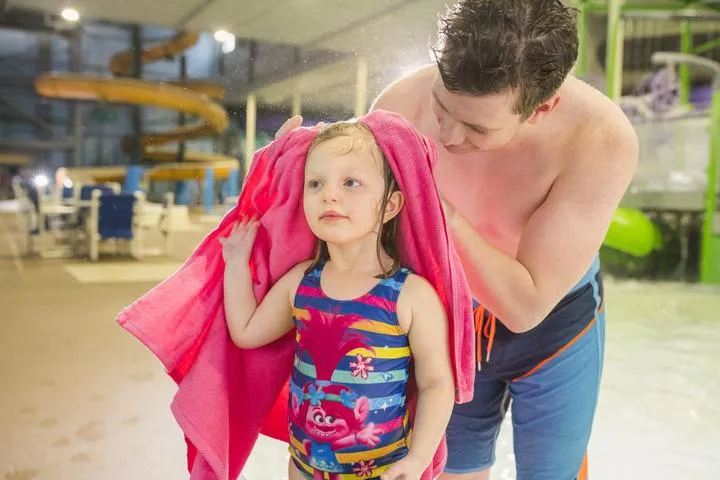 A dad helping his daughter dry off at Chaos Water Park