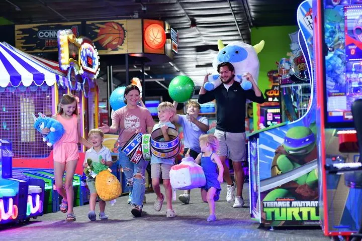 A family walking through Action City with arcade prizes.