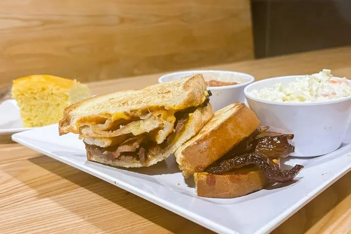 City Eats Beef Brisket Sandwich with cheddar cheese, BBQ, and onion ring on Texas Toast.