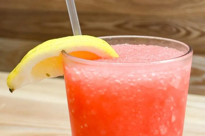 City Eats Strawberry Lemonade Slushie with Absolut Citron, lemonade, strawberry puree, blended and garnished with a lemon wedge.