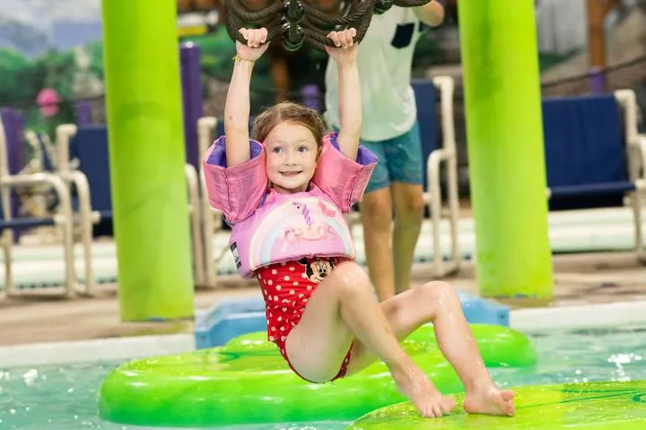 Girl splashing in the Chaos Water Park aquatic playground.