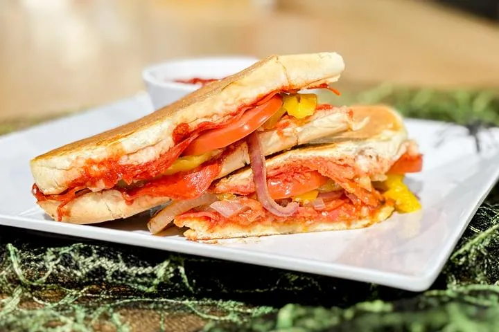 City Eats Beef Brisket Sandwich with cheddar cheese, BBQ, and onion ring on Texas Toast.