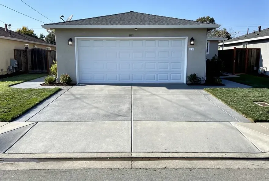 Newly finished concrete driveway attached to a garage door at a residential home in Redwood City, CA