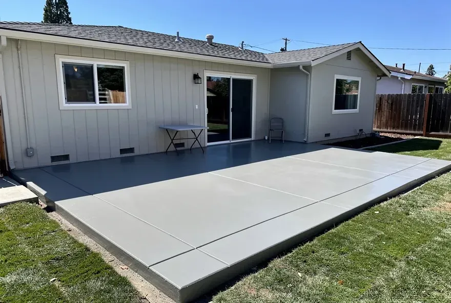 Freshly poured concrete patio attached to the back of a modest home in Redwood City, California