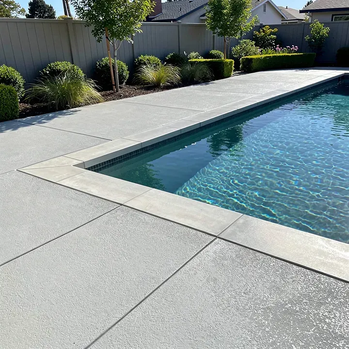 Freshly finished concrete pool deck surrounding an upscale backyard pool in Redwood City, California