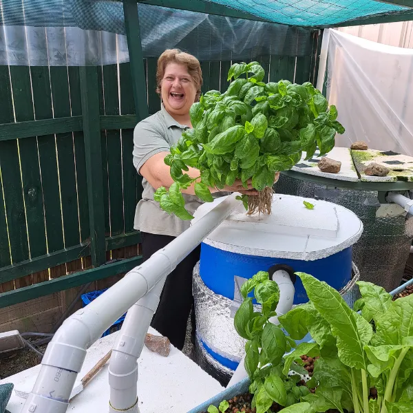 Candy Alexander from The Aquaponics Lady beside a backyard aquaponics system
