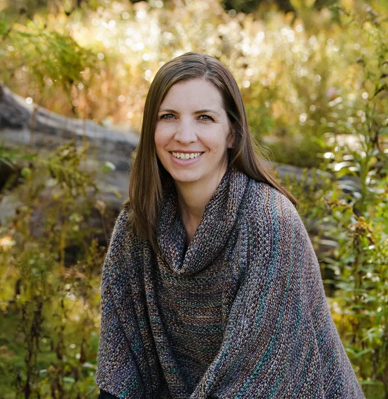 Tara Vicars sits in the woods