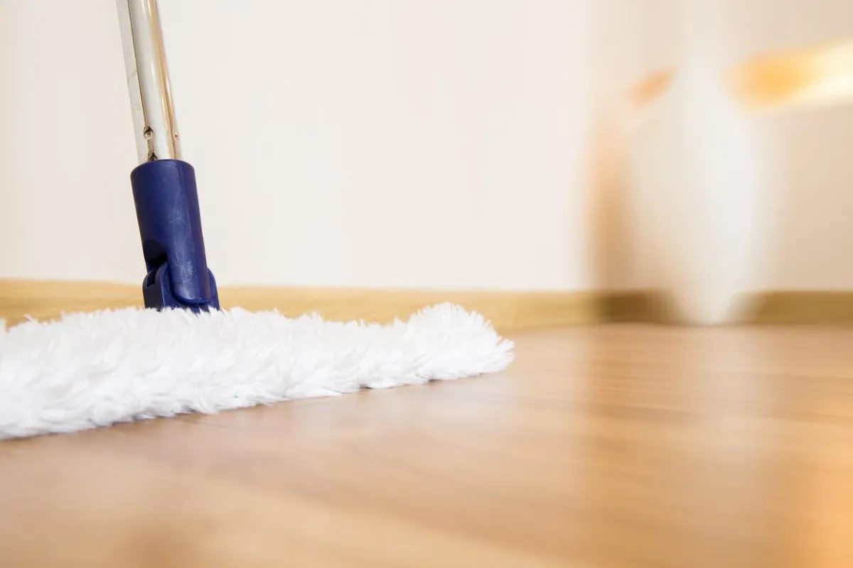 Homeowner cleaning or maintaining hardwood floors
