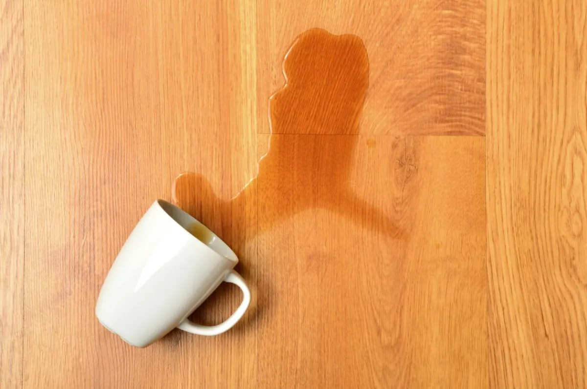 Spilled liquid on hardwood floor showing importance of quick cleaning