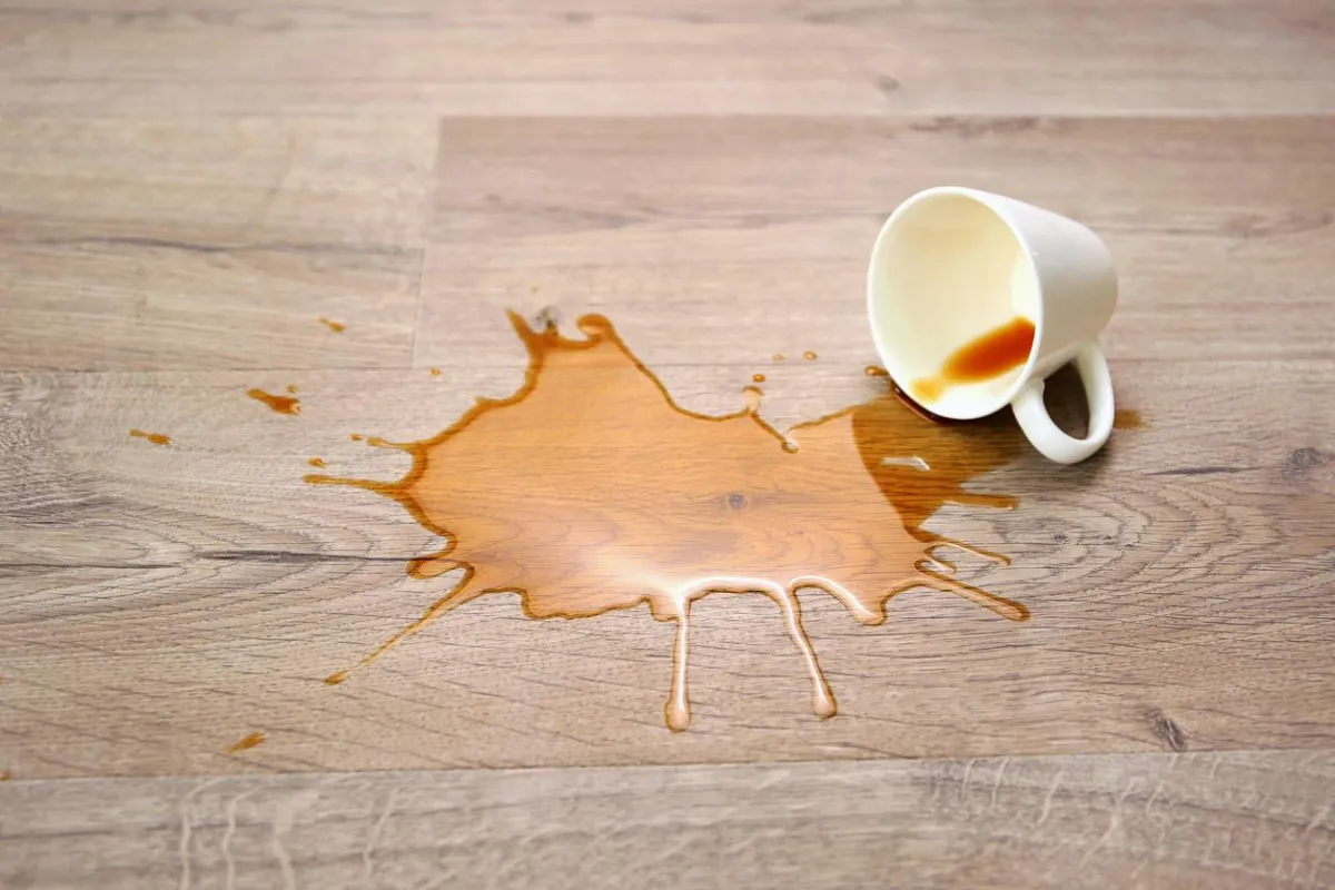 Spilled tea on laminate flooring highlighting need for proper care