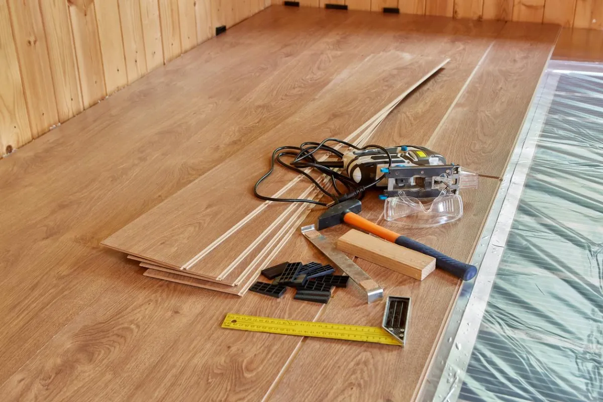Installation tools laid out on a vinyl floor for preparation before flooring installation