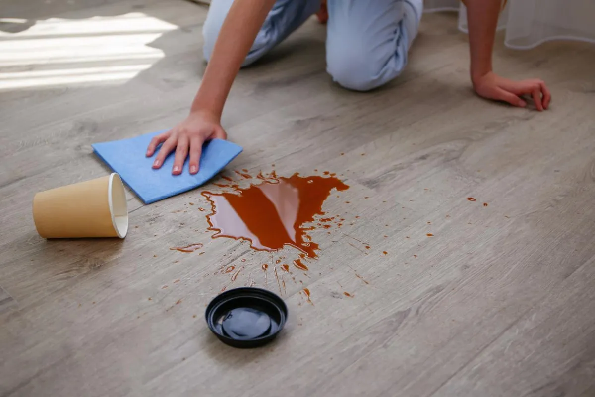 Close-up of a tea spill on a vinyl floor surface showing stain before cleaning