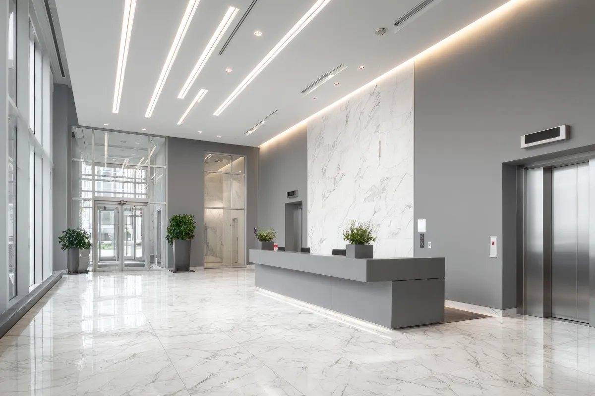 Modern commercial lobby with polished tile flooring, clean lines, and contemporary lighting.