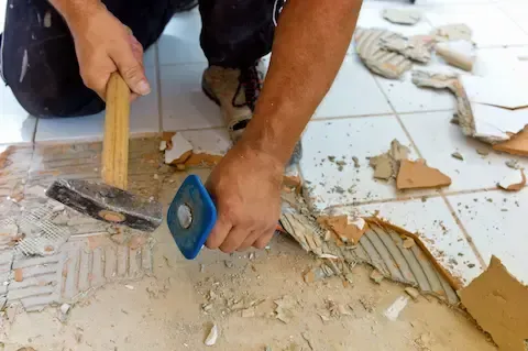 Contractor removing old tile flooring during renovation by Eden Prairie Remodeling Pros.