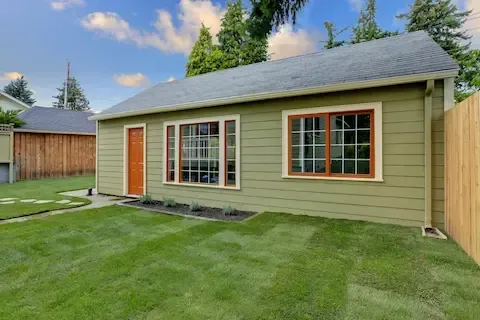 Modern backyard home addition with green siding by Eden Prairie Remodeling Pros.