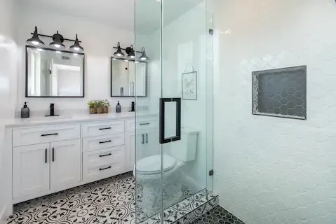 Bright bathroom remodel with glass shower and patterned tile by Eden Prairie Remodeling Pros.