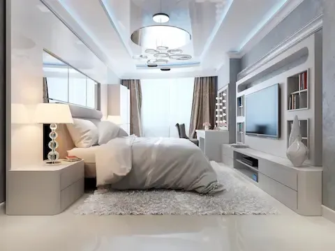 Modern master suite remodel with plush bed and built-in TV wall by Eden Prairie Remodeling Pros.