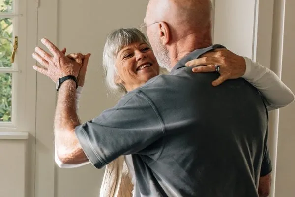 Older couple dancing together at home