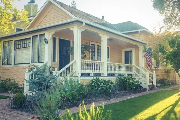 Yellow house with a front porch and an American flag