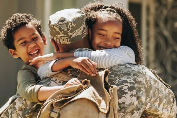Soldier hugging his children as he comes home
