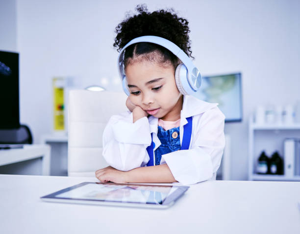 Boy holding a tambourine while watching the teacher on his tablet