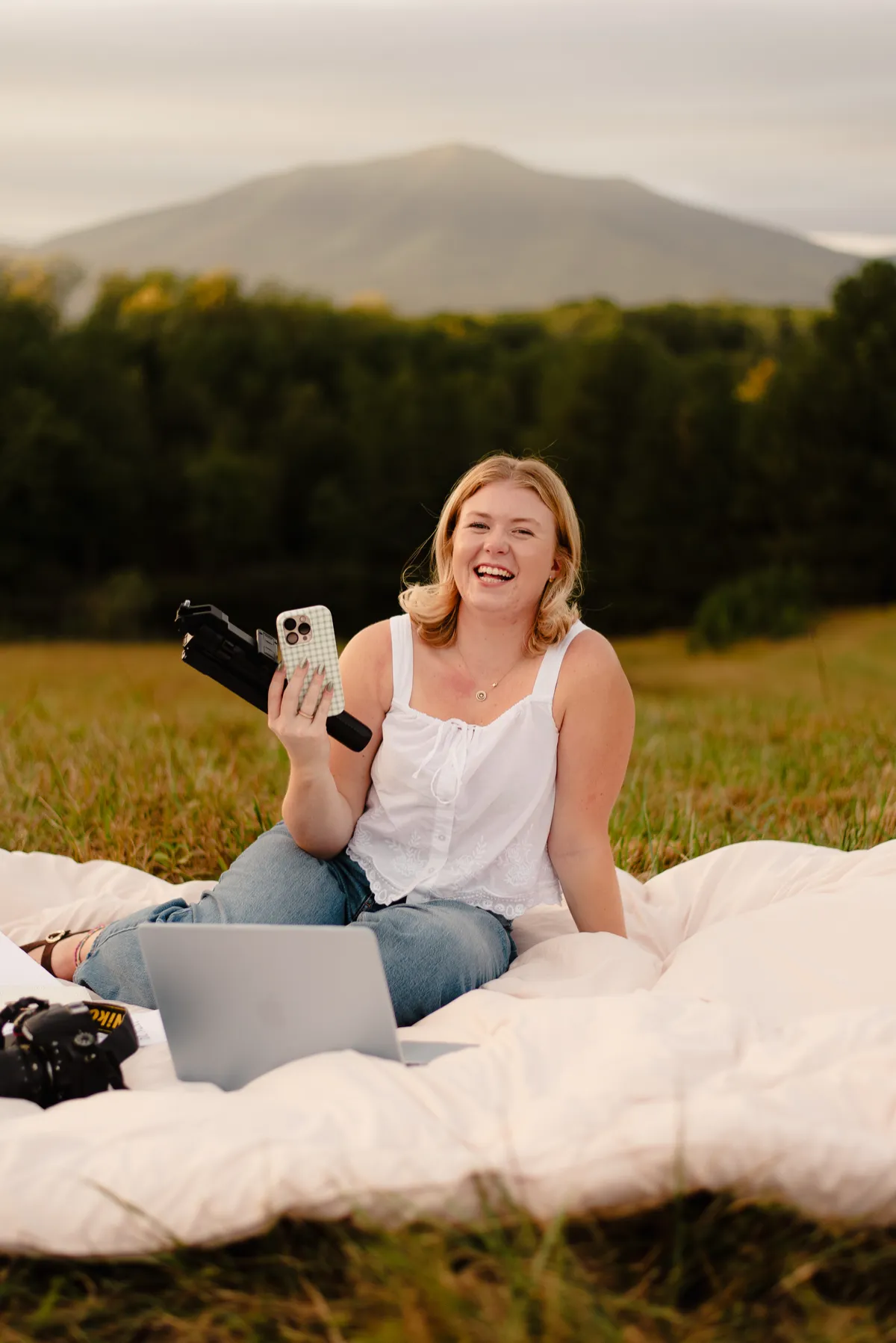 Madi Byrd, founder of Face the Son Creative, working outdoors with mountain views