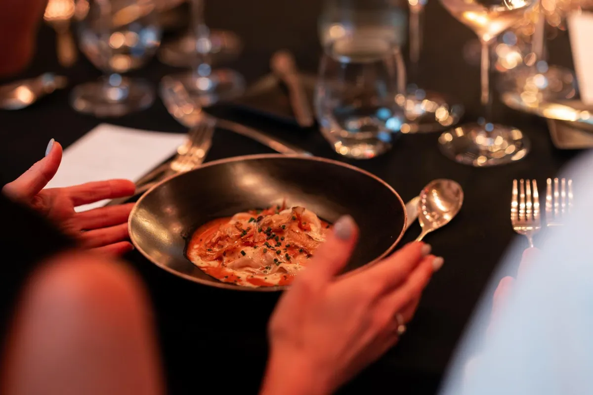 Cropped image of a speaker leading a small professional workshop with participants taking notes, conveying learning and engagement.